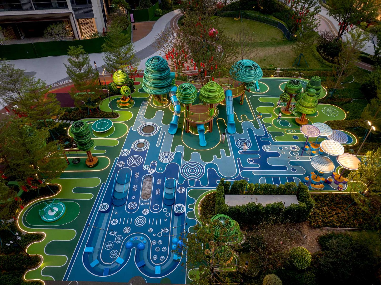 Top-down view of the flowing blue and green ground pattern with the tree structures rising from it.