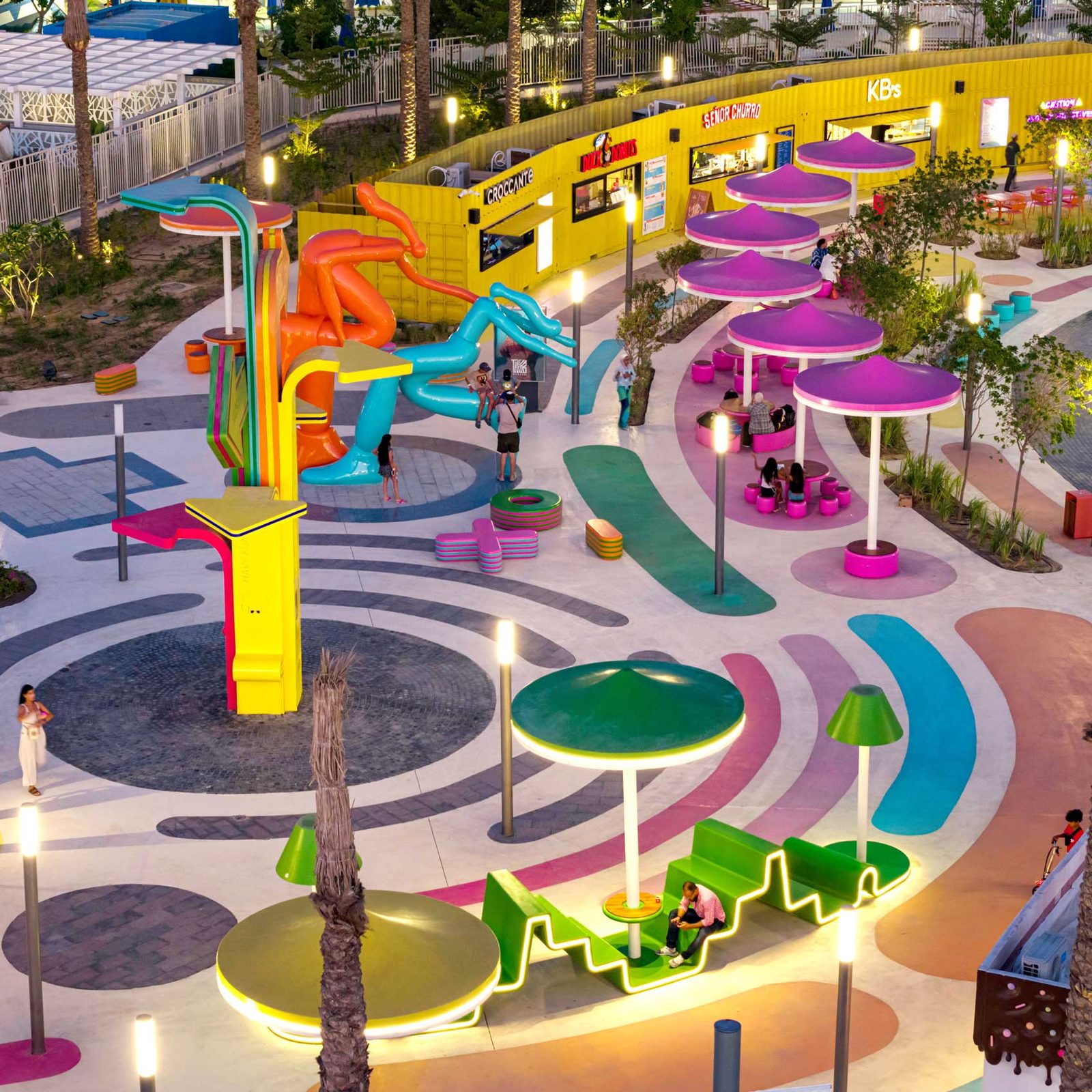 The destination at dusk, its slides, canopies and lighting glowing above the patterned ground.