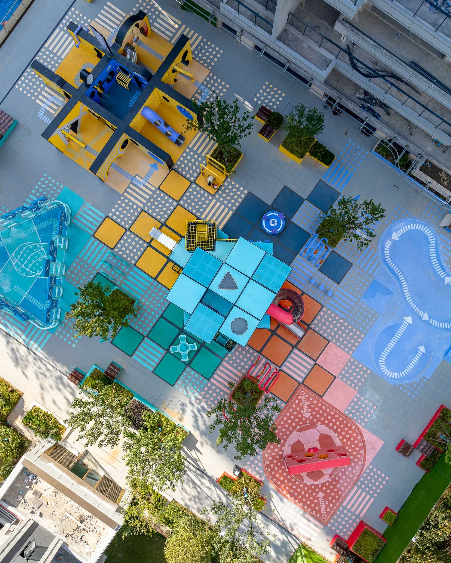 Daytime aerial view showing the blue and pink patterned ground surface stepping through the plaza.